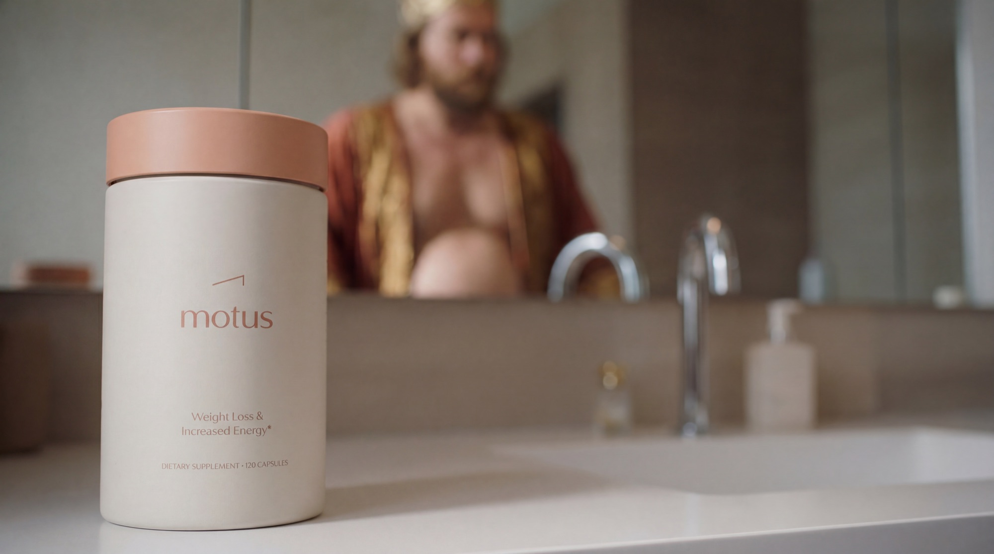 King Motus film still: a Motus supplement bottle on the bathroom counter, with the pre-Motus Midas reflected in the mirror behind.